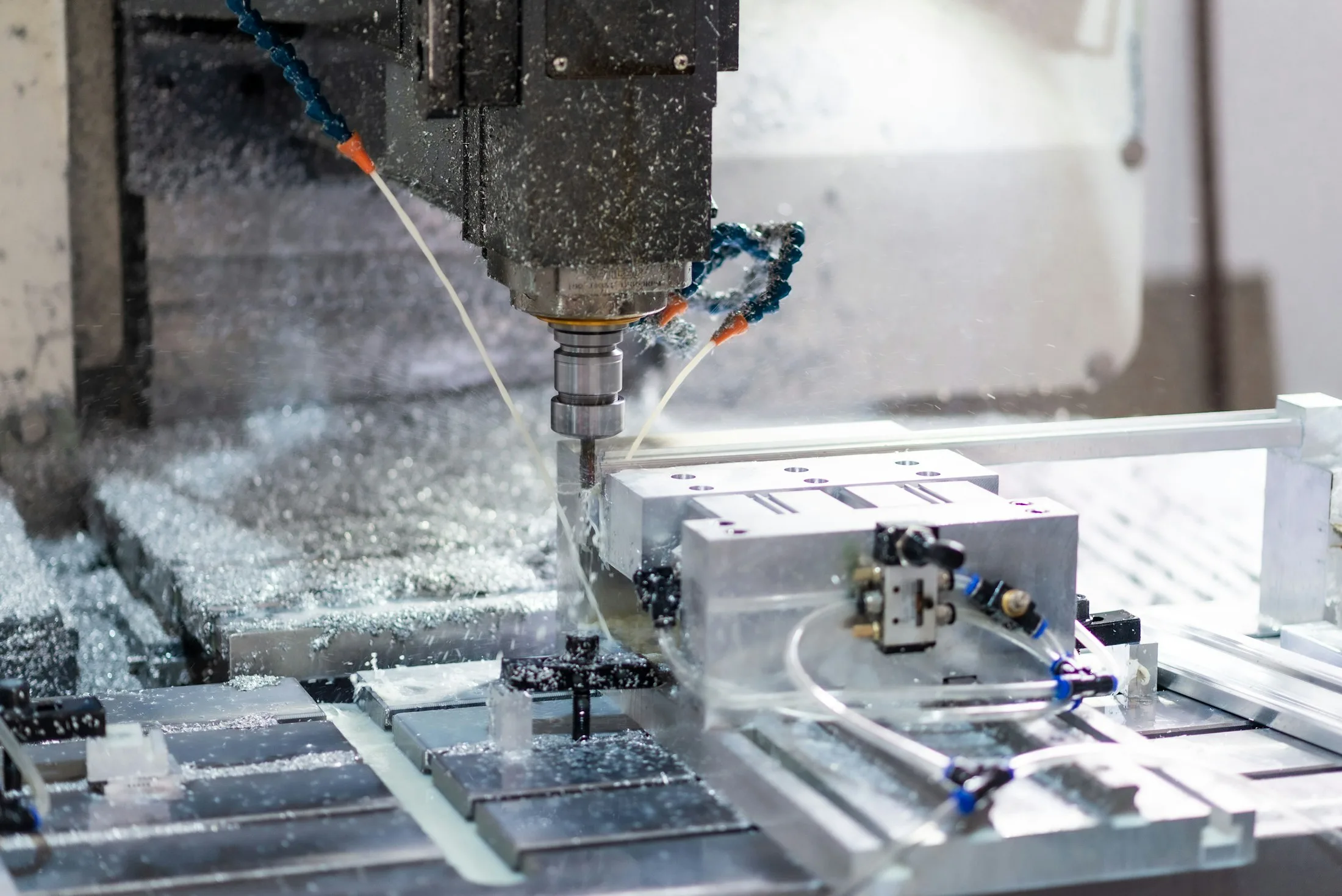 CNC milling spindle cutting an aluminum workpiece inside a machine enclosure